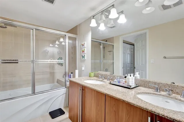 a bathroom with a granite countertop sink mirror and double