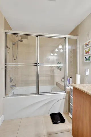 a bathroom with a sink a mirror and a glass door shower