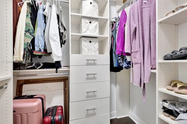 a view of walk in closet with clothes and shoes