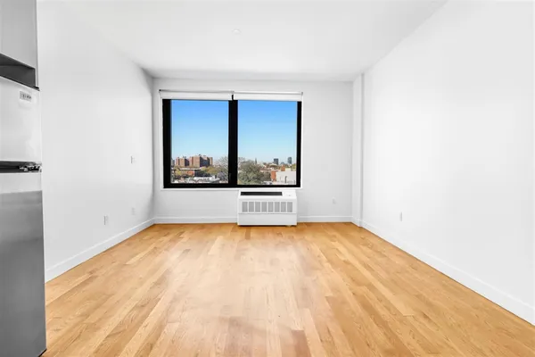 a view of a room with wooden floor and a window