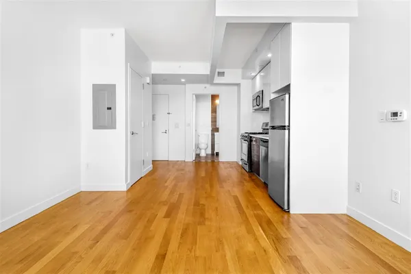 a view of a bedroom with wooden floor and a hallway