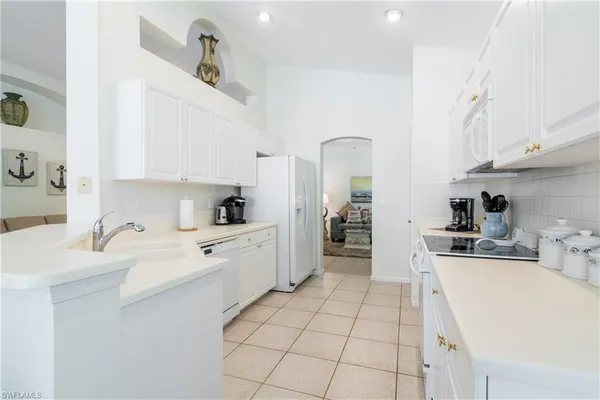 a large white kitchen with cabinets