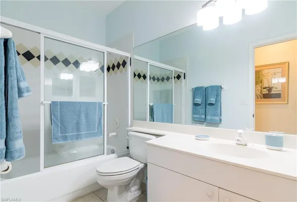 a bathroom with a double vanity sink toilet mirror and shower