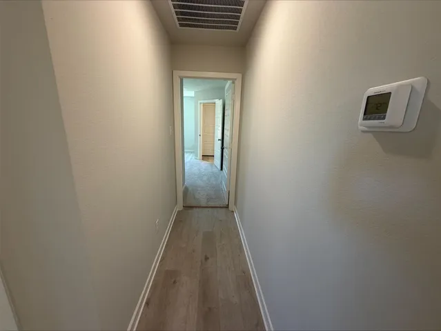 a view of a hallway with wooden floor