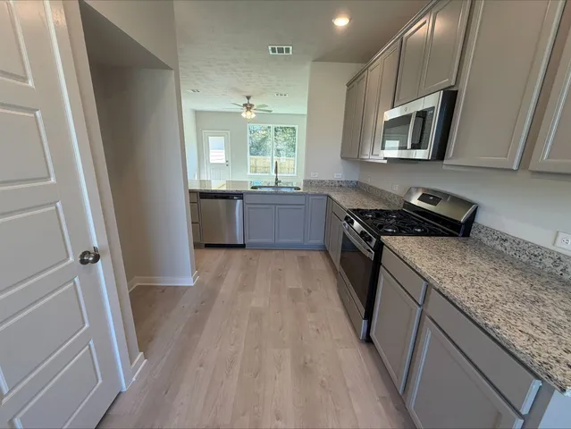 a kitchen with a sink a microwave a stove and refrigerator