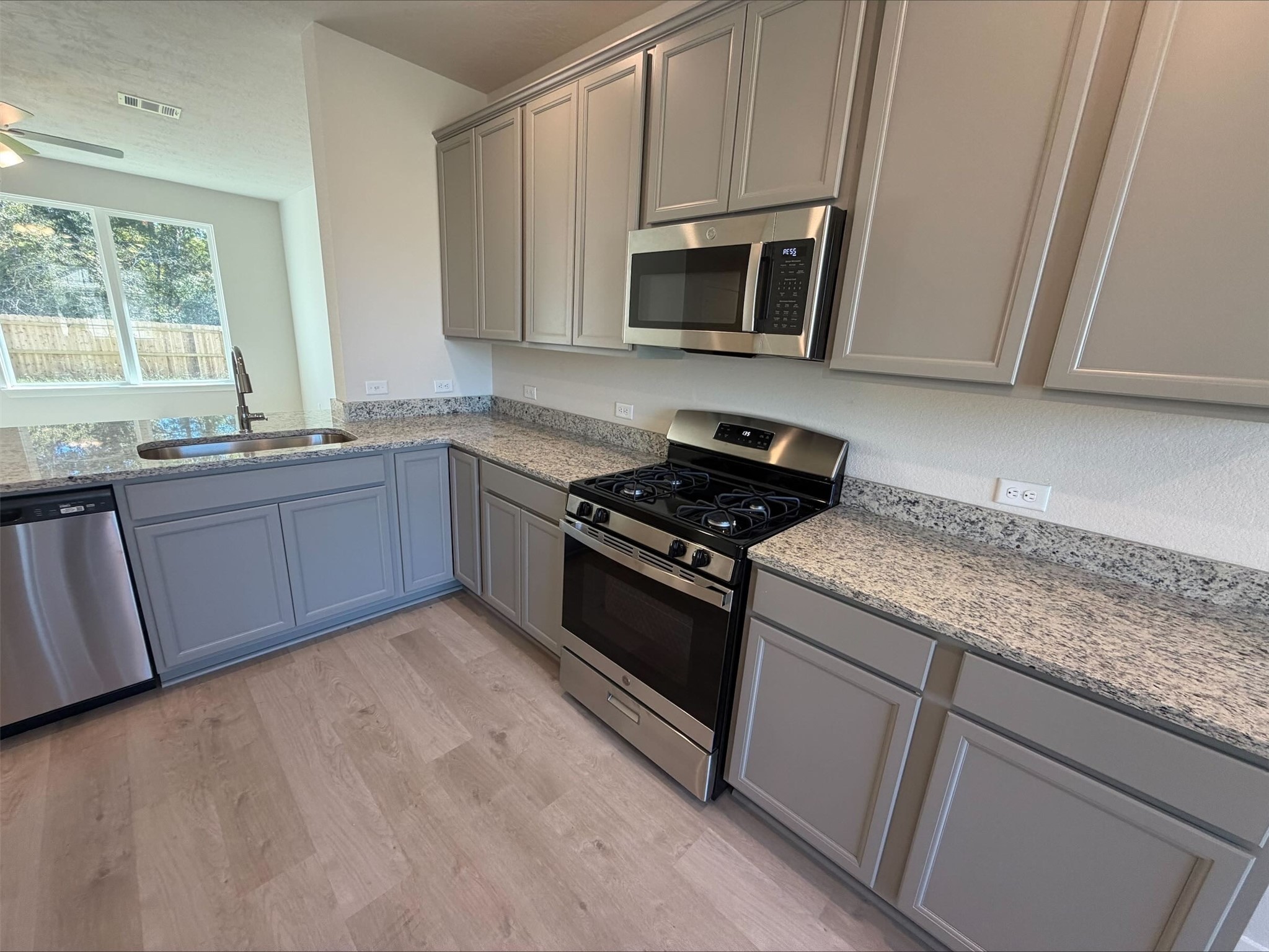 237 New Dawn Trail Huntsville, TX 77320 - Photo 6 of 23 a kitchen with granite countertop stainless steel appliances a sink stove and microwave