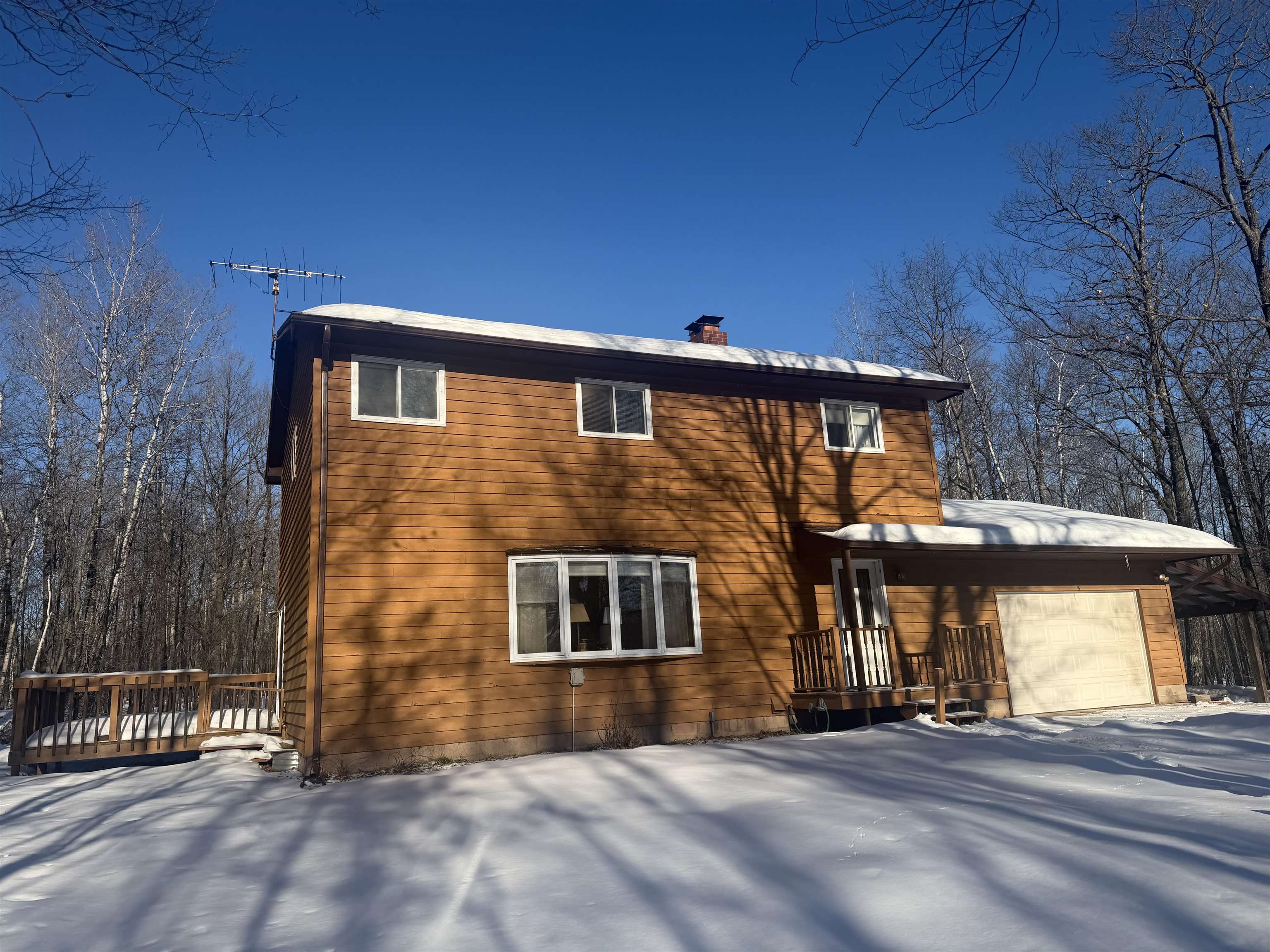 25200 Fischer Road Ashland, WI 54806 - Photo 2 of 5 View of front of house featuring an attached garage, a chimney, and a deck