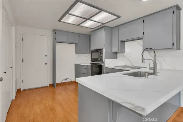 a kitchen with stainless steel appliances a stove a sink and a microwave
