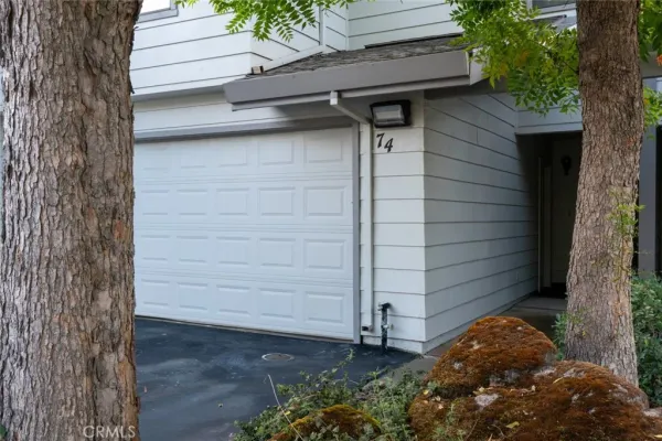 a front view of a house with a tree