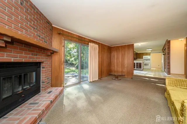 an empty room with a fireplace and windows