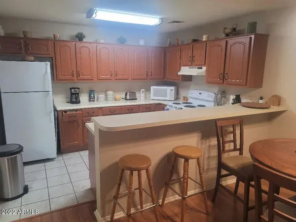 a kitchen with stainless steel appliances a white table chairs and a refrigerator
