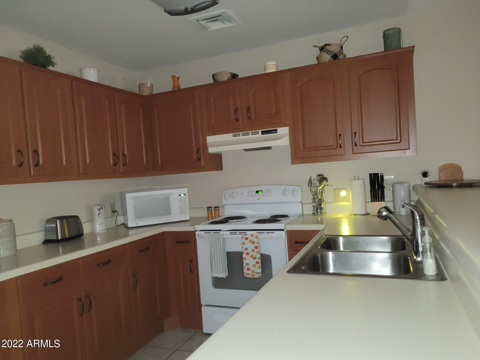 14300 West Bell Road, Unit 513 Surprise, AZ 85374 - Photo 13 of 23 a kitchen with stainless steel appliances a sink a stove and cabinets