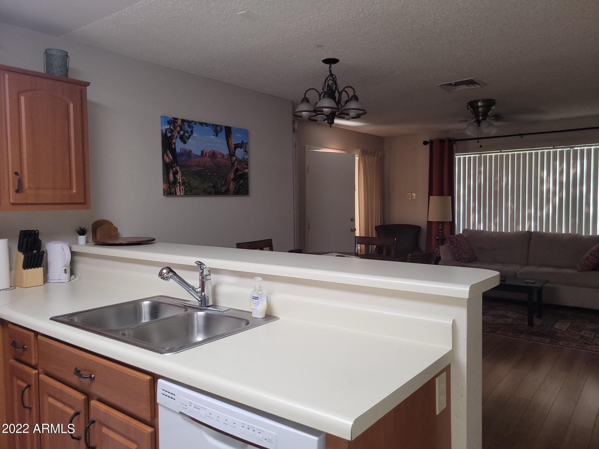 14300 West Bell Road, Unit 513 Surprise, AZ 85374 - Photo 14 of 23 a kitchen with a sink a stove and a refrigerator