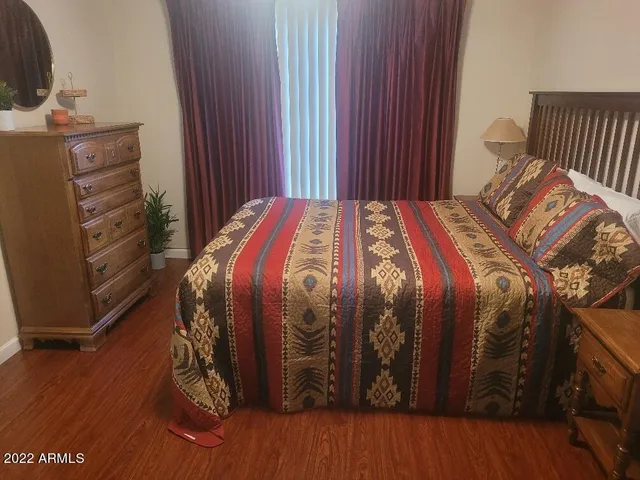 a bedroom with a bed and wooden floor