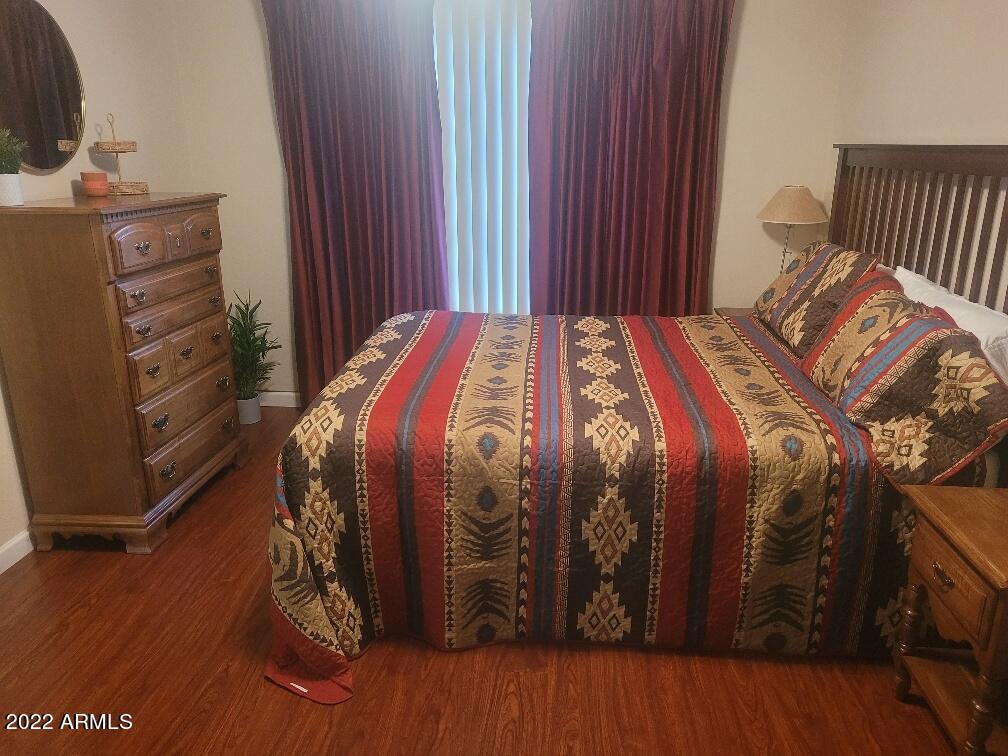 14300 West Bell Road, Unit 513 Surprise, AZ 85374 - Photo 15 of 23 a bedroom with a bed and wooden floor