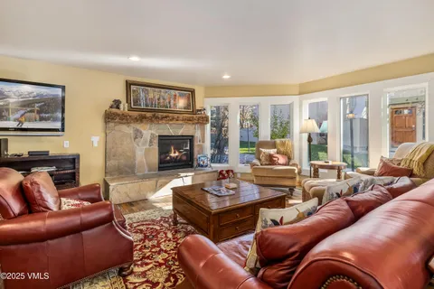 a living room with furniture fireplace and a large window