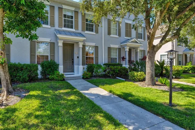 a view of a brick house with a yard and plants