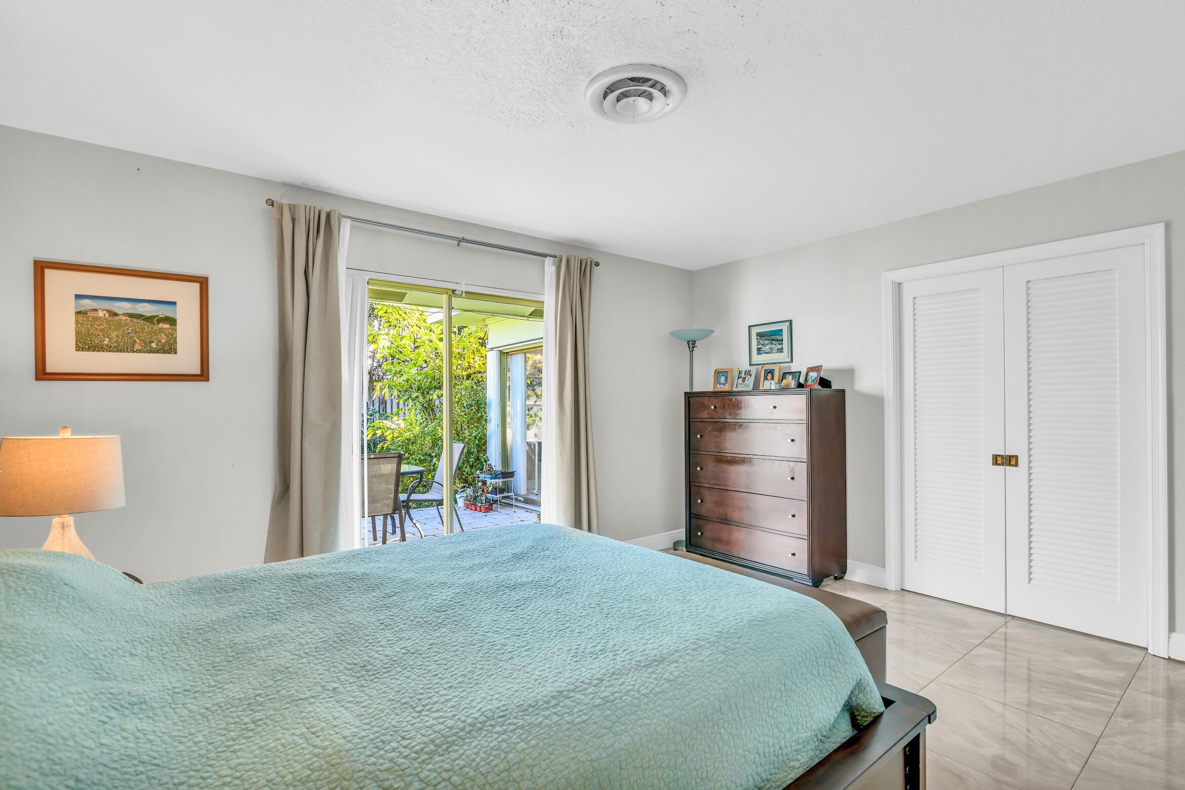 1290 Southwest 8th Street Boca Raton, FL 33486 - Photo 21 of 36 a bed room with a bed and a lamp