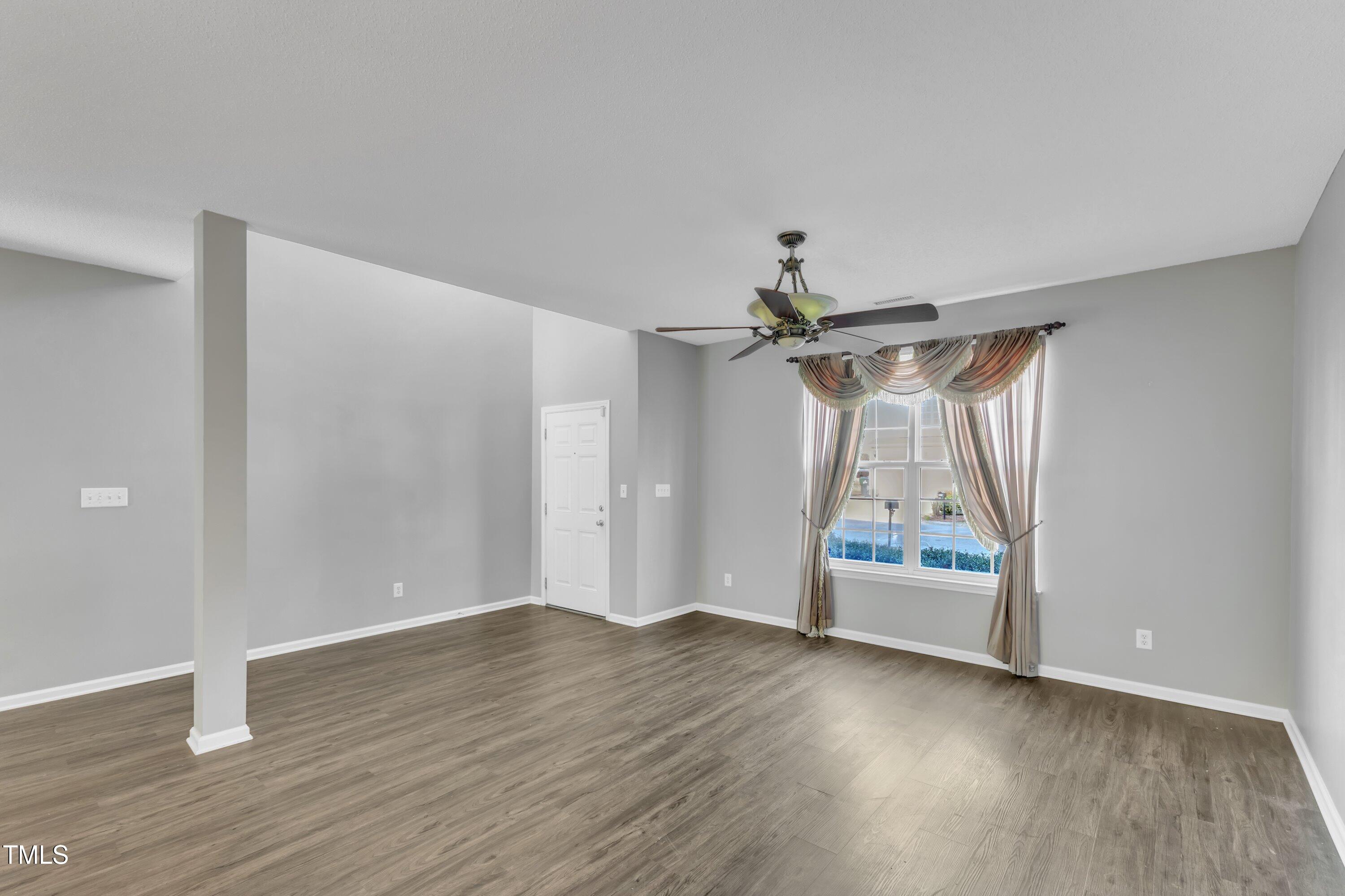 3408 Dutchman Road Raleigh, NC 27610 - Photo 11 of 54 an empty room with wooden floor ceiling fan and windows
