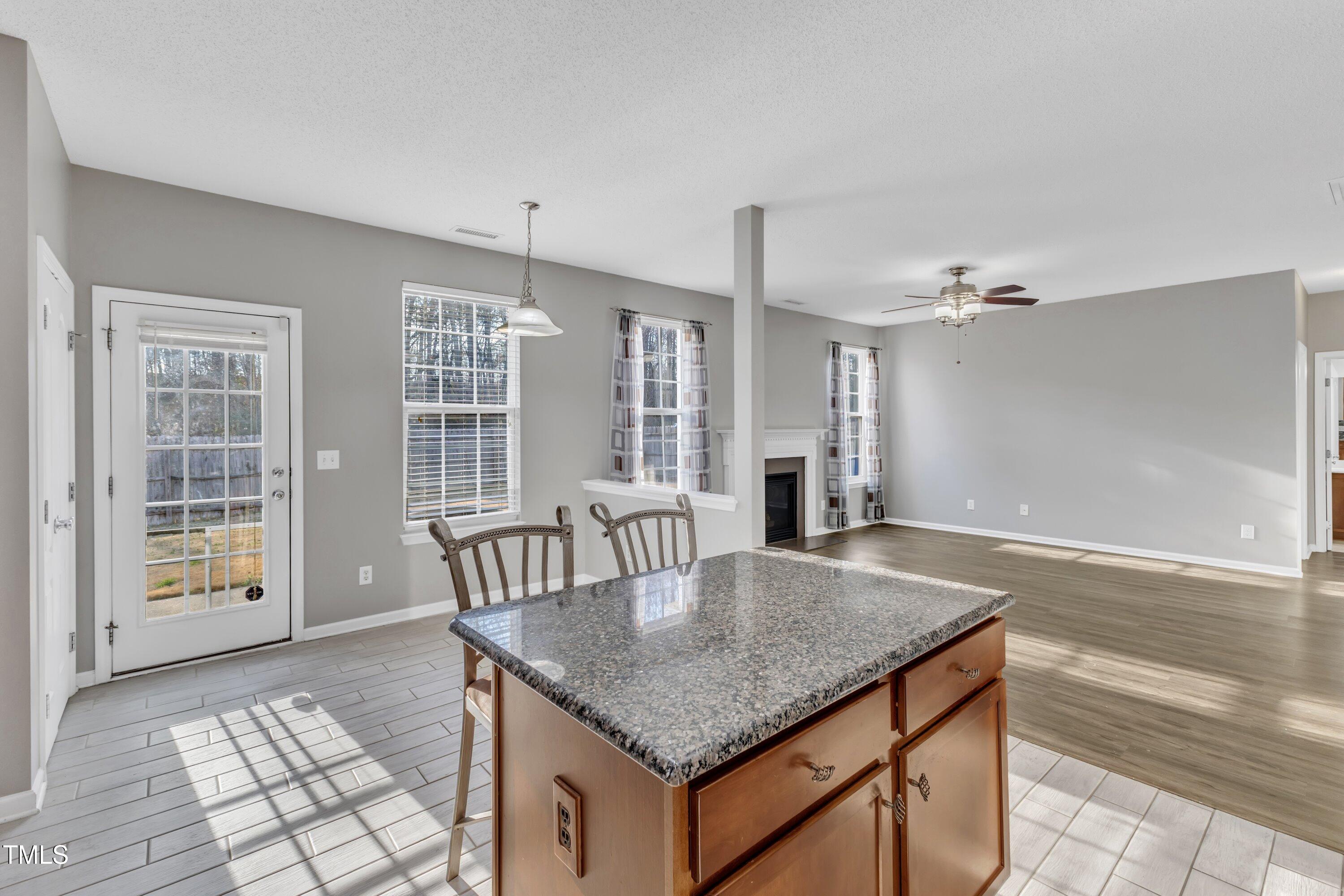 3408 Dutchman Road Raleigh, NC 27610 - Photo 27 of 54 a kitchen with granite countertop a table chairs and wooden floor