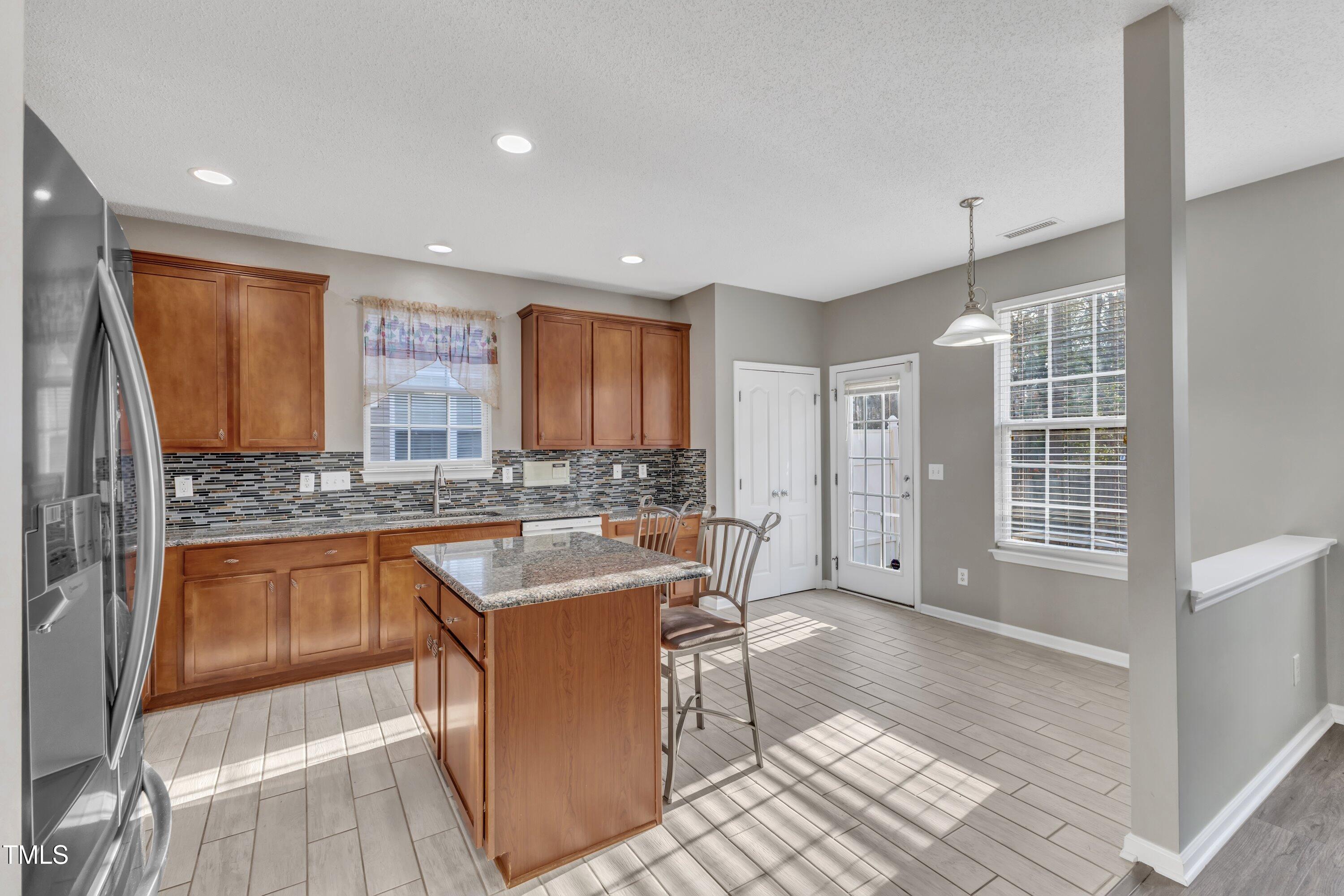 3408 Dutchman Road Raleigh, NC 27610 - Photo 28 of 54 a kitchen with granite countertop a sink and a refrigerator