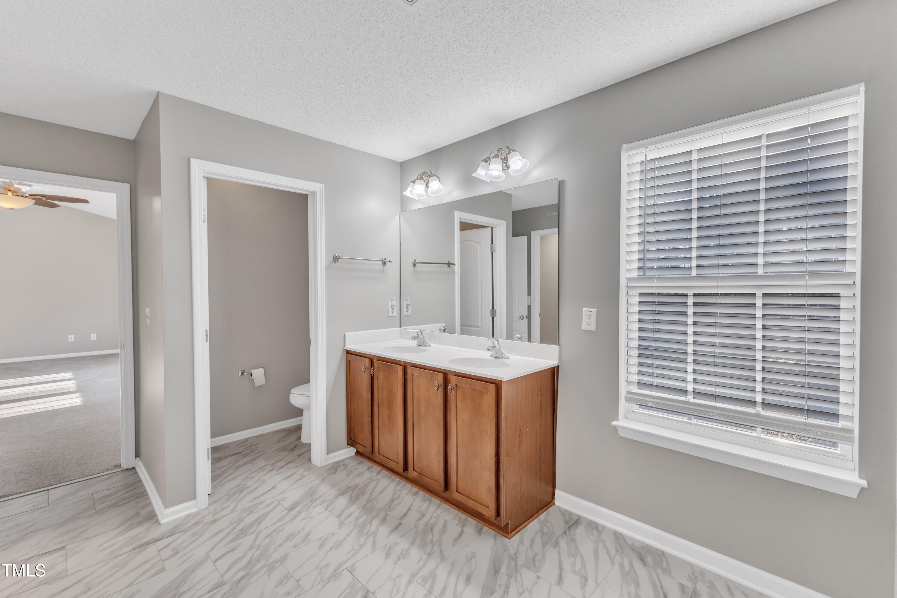 3408 Dutchman Road Raleigh, NC 27610 - Photo 40 of 54 a view of bathroom with dual sinks and a window