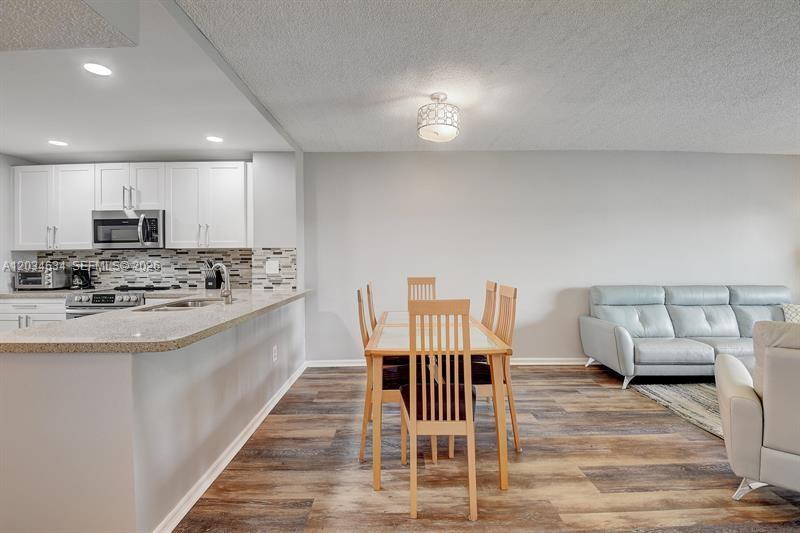 9880 Marina Boulevard, Unit 1516 Boca Raton, FL 33428 - Photo 6 of 32 a kitchen with stainless steel appliances kitchen island granite countertop a sink and cabinets