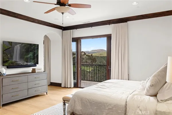 a bedroom with a bed and a flat tv screen on dresser