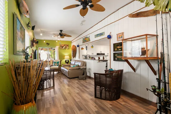 a view of a livingroom with furniture a ceiling fan and wooden floor