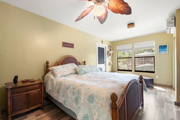 a bedroom with a bed and a flat tv screen on dresser