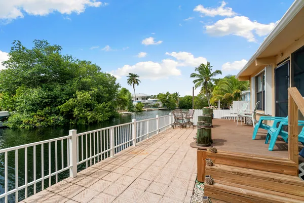 a view of a patio with dining table and chairs with wooden floor