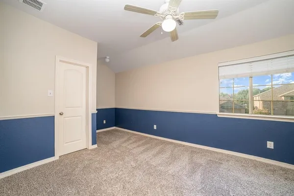 an empty room with windows and fan