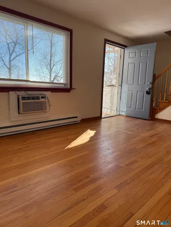 a view of a livingroom with wooden floor and a window