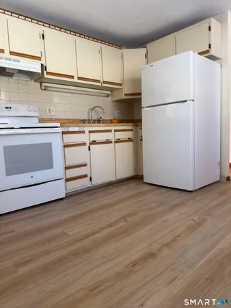 a kitchen with a refrigerator sink and cabinets