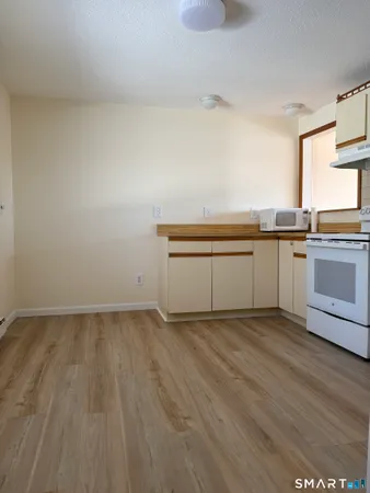 a view of a kitchen with wooden floor and a sink