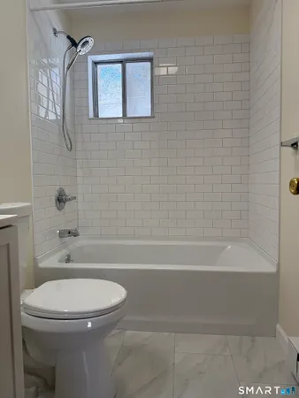 a bathroom with a toilet and a bath tub