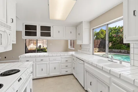 a view of a kitchen with a sink dishwasher a refrigerator and a fireplace