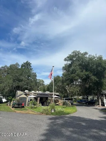 a view of a house with backyard and sitting area