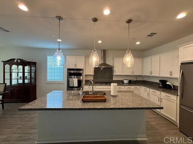 a kitchen with stainless steel appliances granite countertop a sink refrigerator and microwave