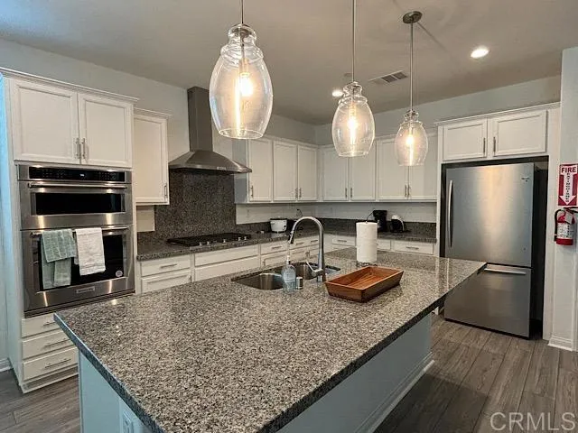 a kitchen with stainless steel appliances granite countertop a sink refrigerator and microwave