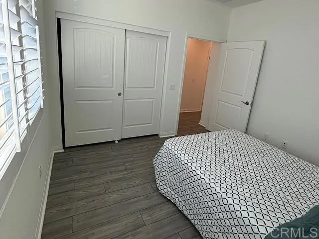 a bedroom with a bed and hardwood floor