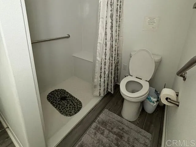 a white toilet sitting next to a sink and vanity