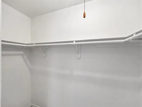 a view of walk in closet with empty racks