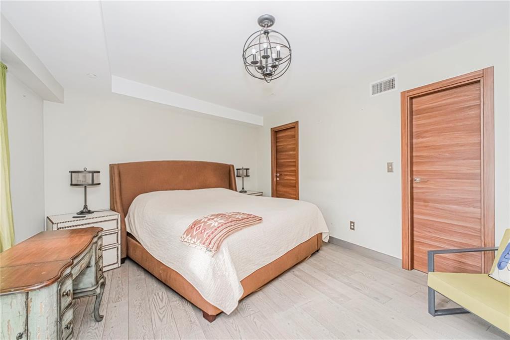 3567 Shore Parkway, Unit H4A Brooklyn, NY 11235 - Photo 11 of 35 a bedroom with a bed and a chandelier