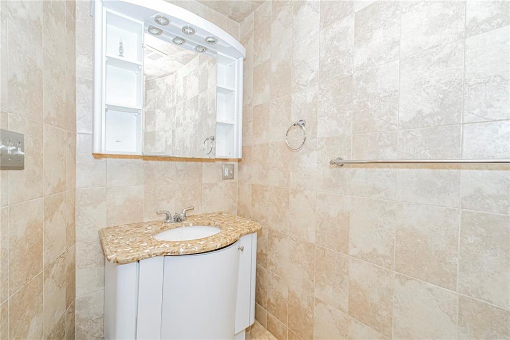 3567 Shore Parkway, Unit H4A Brooklyn, NY 11235 - Photo 14 of 35 a bathroom with a granite countertop sink and a mirror