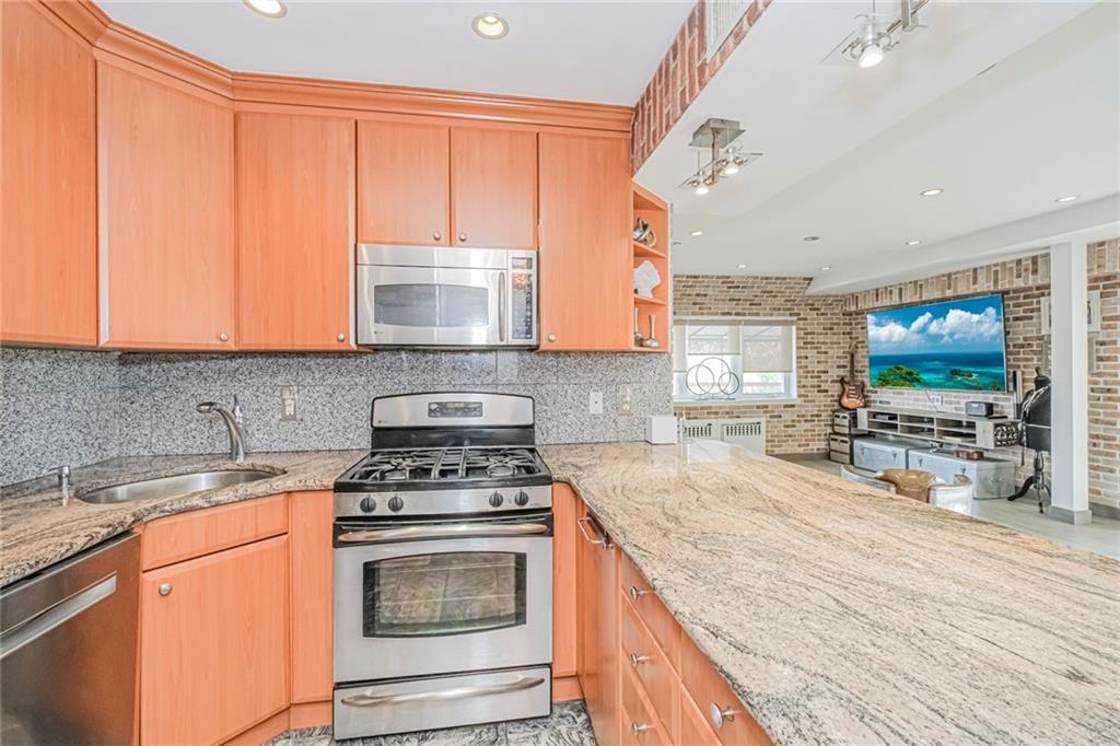 3567 Shore Parkway, Unit H4A Brooklyn, NY 11235 - Photo 9 of 35 a kitchen with a stove a sink and a microwave