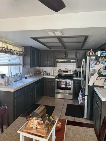 a kitchen with stainless steel appliances kitchen island granite countertop a refrigerator stove and sink