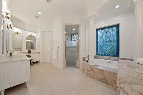 a spacious bathroom with a tub sink and mirror