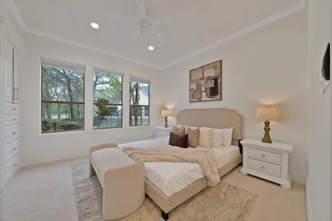 a bedroom with a bed and a large window