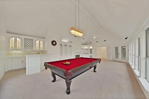 a living room with furniture pool table and window